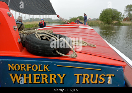 À la barre de l'historique commercial Norfolk wherry Albion, la voile sur la rivière Bure, Broads National Park Banque D'Images