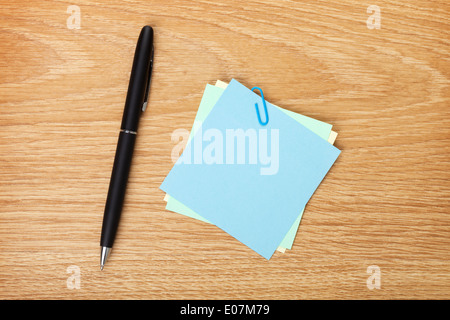 Post-it en blanc avec un stylo sur la table en bois du bureau. Voir ci-dessus Banque D'Images