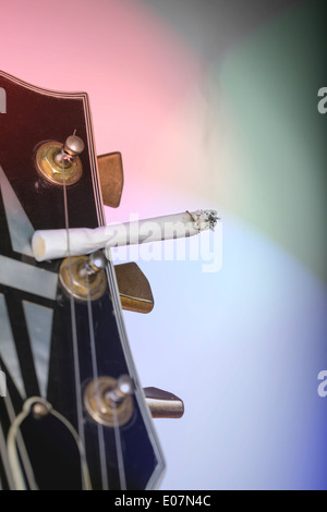 Gros plan d'une tête de guitare avec cigarette coller sous une seule corde. Banque D'Images