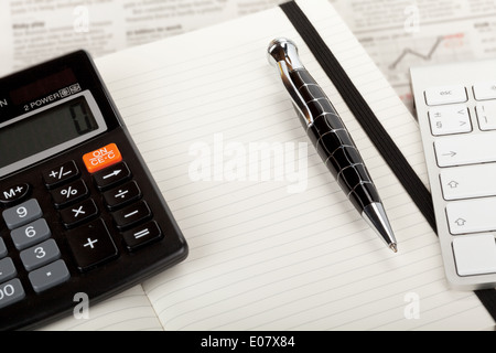 Journal d'affaires sommaire avec livre ouvert, un clavier et une calculatrice. Banque D'Images
