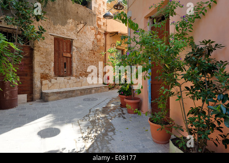 Pierre étroite ruelle bordée de carrelage aux façades colorées des plantes en pot rue Vieille ville de Chania Crète Grèce Banque D'Images