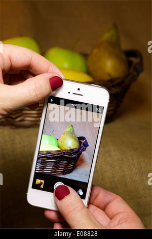 Photographier une personne de fruits dans un panier avec un téléphone mobile / appareil photo UTILISEZ UNIQUEMENT ÉDITORIALE Banque D'Images