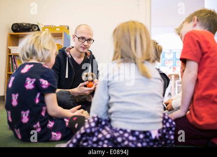 Enseignant jouant avec des enfants en maternelle Banque D'Images