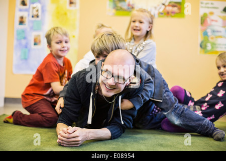 L'enseignant et les enfants bénéficiant de la maternelle Banque D'Images