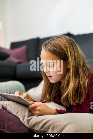 Girl using digital tablet in living room Banque D'Images