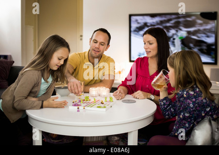 Family playing ludo dans la salle de séjour Banque D'Images