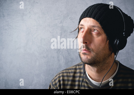 L'homme non rasé occasionnels avec casque noir est à l'écoute de la musique Banque D'Images