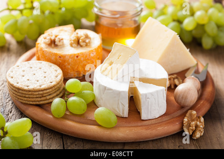 Assiette de fromage avec camembert, cheddar, les raisins et le miel Banque D'Images