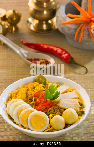 Curry épicé nouilles instantanées. La cuisine asiatique, prêt à servir sur table à manger en bois. Douce chaude avec de la fumée. Banque D'Images