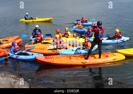 Les jeunes enfants qui reçoivent l'instruction au sujet de kayak au Weymouth and Portland National Sailing Academy WPNSA Dorset Angleterre Banque D'Images