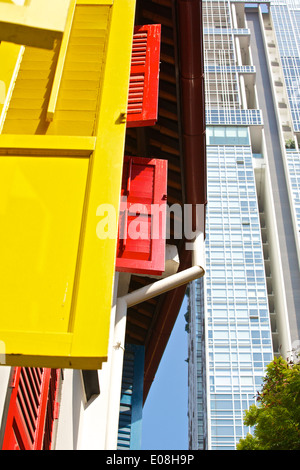 L'architecture contrastée, bâtiment colonial restauré aux volets colorés avec des tours en arrière-plan, à Singapour. Banque D'Images