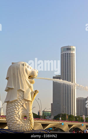 Le Merlion Fontaine avec le Swissotel en arrière-plan, à Singapour. Banque D'Images