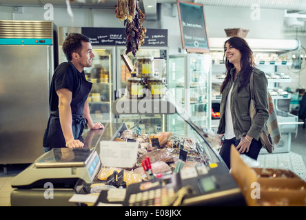 Vue latérale du salesman attending female customer in supermarket Banque D'Images