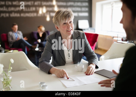 Senior businesswoman discutant avec collègue masculin à l'office de tourisme 24 Banque D'Images