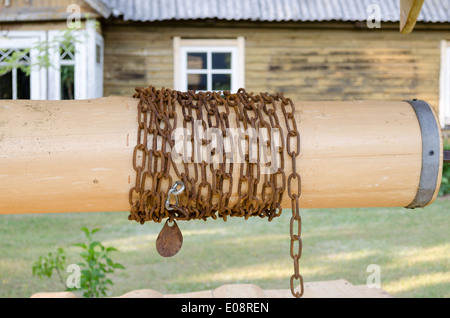 Close up of wooden rouleau bien avec chaîne en cour de pays Banque D'Images