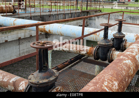 Rusty big touchez obturation et usine de traitement de l'eau dans les tuyaux et sale bulle liquide en arrière-plan. Banque D'Images