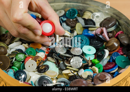 Lave plein de différents boutons colorés et couturière needlewoman gratter elle usée.