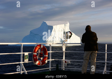 Man taking photograph of iceberg géant à bord d'un navire en antarctique Banque D'Images