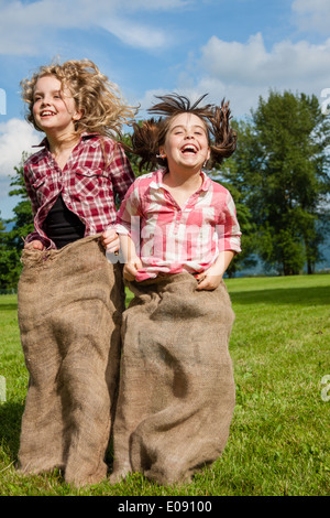 Des filles dans un sac de jute race Banque D'Images