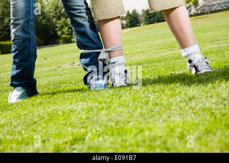 Garçon et fille prête pour un 3-legged race Banque D'Images