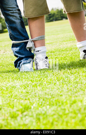 Garçon et fille prête pour un 3-legged race Banque D'Images