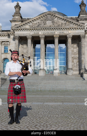 Un cornemuseur écossais joue de la cornemuse en face du bâtiment du Reichstag à Berlin, Allemagne Banque D'Images