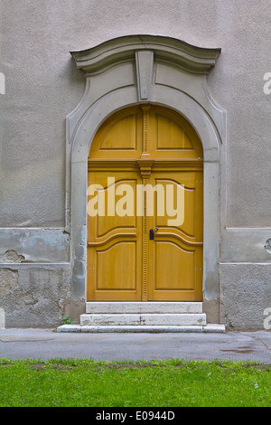 Porte latérale jaune sur l'ancienne église mur. Banque D'Images