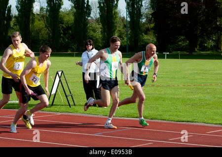L'athlétisme, les coureurs passant baton dans men's 4x400m relais course à l'étage club, UK Banque D'Images