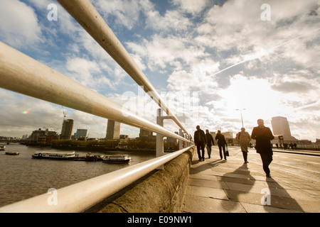 Les gens se profilant crossing London's Waterloo Pont sur la Tamise. Banque D'Images