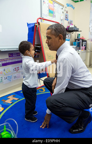 Le président américain Barack Obama laisse un petit garçon écouter son rythme cardiaque avec un stéthoscope au cours d'une visite de classe à l'école élémentaire Powell le 4 mars 2014 à Washington, DC. Banque D'Images