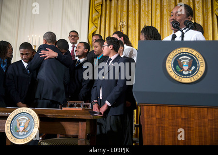 Le président américain Barack Obama en étreignant un participant après la signature d'un mémorandum présidentiel instituant le gardien de mon frère le Groupe de travail, lors d'un événement pour mettre en surbrillance "mon Brother's Keeper", une initiative visant à élargir les possibilités pour les jeunes hommes et les garçons de couleur, dans l'East Room de la Maison Blanche le 27 février 2014 à Washington, DC. Banque D'Images