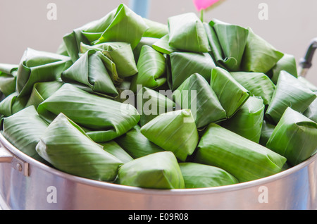 Grand pot plein de riz gluant enveloppé dans des feuilles de bananier et prêt à cuire , dessert asiatique Banque D'Images