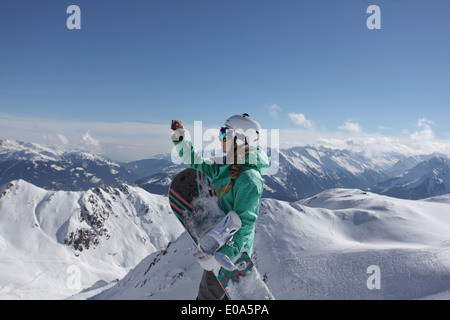 Jeune femelle snow boarder photographier sur la montagne, Mayrhofen, Tyrol, Autriche Banque D'Images