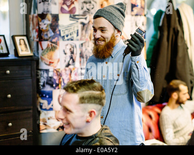 Salon de coiffure de jeune mans cheveux avec clippers Banque D'Images