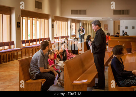 Prêtre catholique accueille les jeunes paroissiens hispaniques avant la messe à une Laguna Niguel, CA, l'église catholique. Banque D'Images