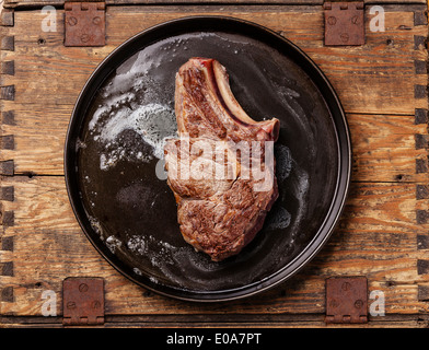 Escalope de veau avec de l'os sur le moule, sur fond de bois Banque D'Images