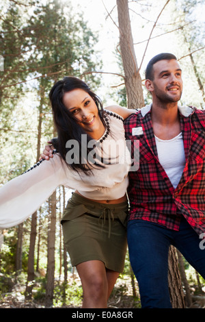 Jeune couple de jouer dans l'aménagement forestier Banque D'Images