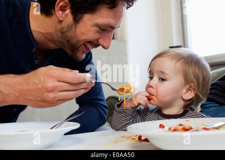 Père à l'âge d'un an d'alimentation spaghetti fille Banque D'Images