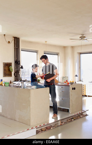 Père et fils avec toy airplane in kitchen Banque D'Images