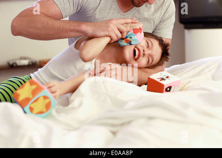 Le père et le jeune fils at bed Banque D'Images