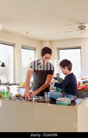 Le père et le jeune fils de compensation dans la cuisine Banque D'Images