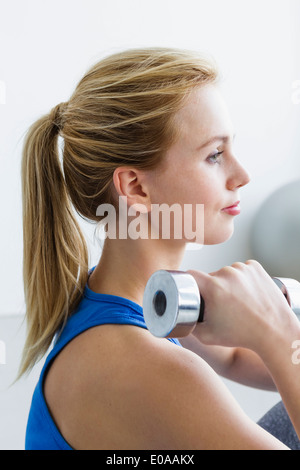 Young woman lifting weights Banque D'Images