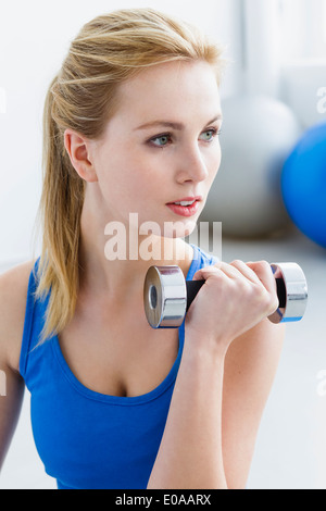 Young woman lifting weights Banque D'Images