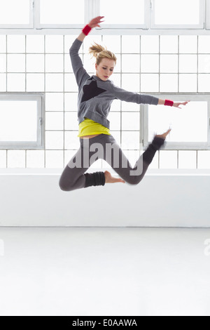 Young woman jumping in gymnasium Banque D'Images