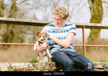 Teenage boy sur passerelle avec son chien Jack Russell Banque D'Images