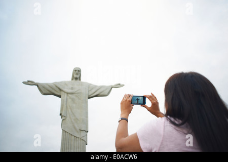 Young woman photographing Christ Rédempteur, Rio de Janeiro, Brésil Banque D'Images