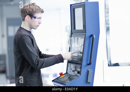 Mid adult male technician maintenir les machines dans l'usine d'ingénierie Banque D'Images
