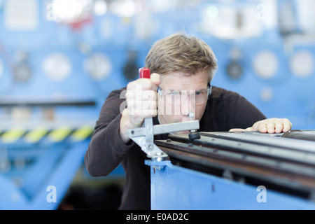 Mid adult male technician contrôler les mesures en usine d'ingénierie Banque D'Images
