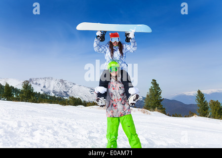 Man in ski mask holding fille avec tête de conseil Banque D'Images