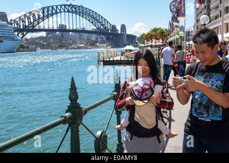 Sydney Australie,East Circular Quay,promenade,Sydney Harbour Bridge,port,homme asiatique hommes hommes,femme femmes,couple,bébé bébés enfants,famille Banque D'Images